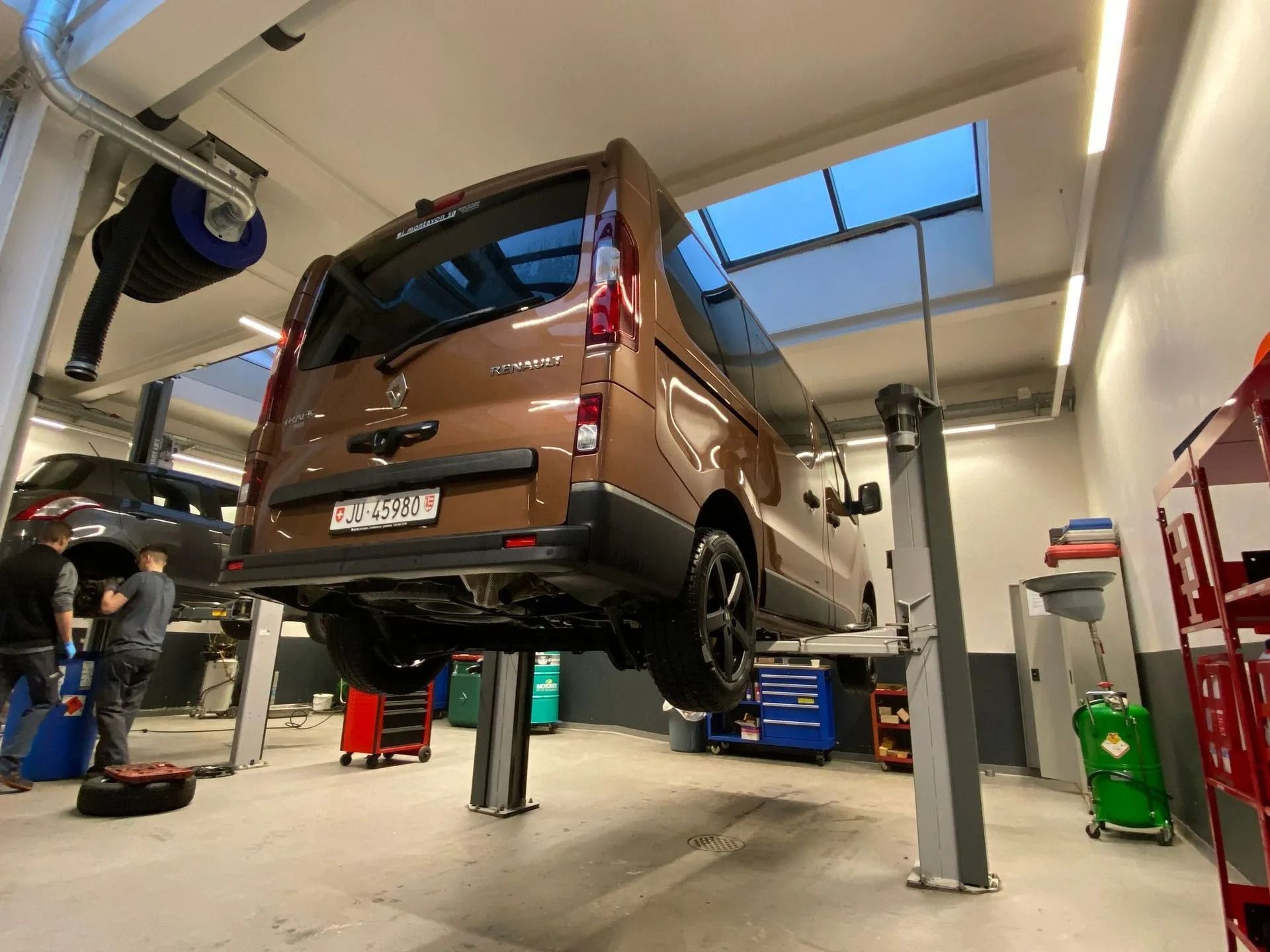 Une camionnette est assise sur un élévateur dans un garage.