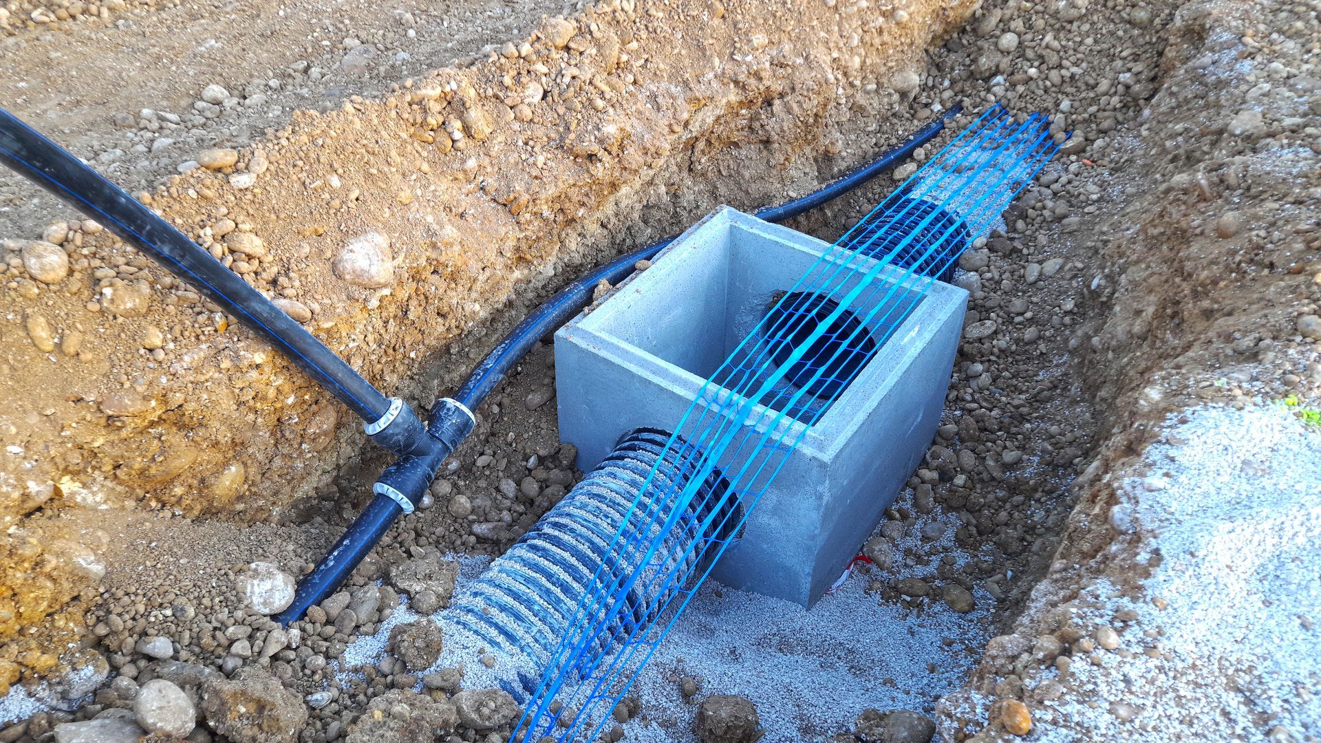 Un bassin de rétention des eaux pluviales en béton relié à des tuyaux.