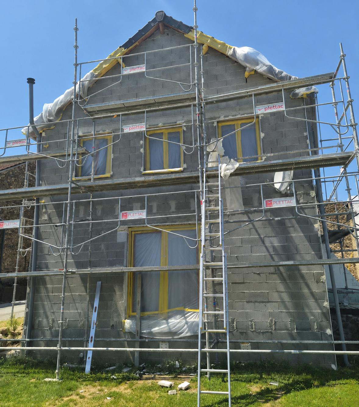 Maison en pierre en rénovation avec échafaudages métalliques