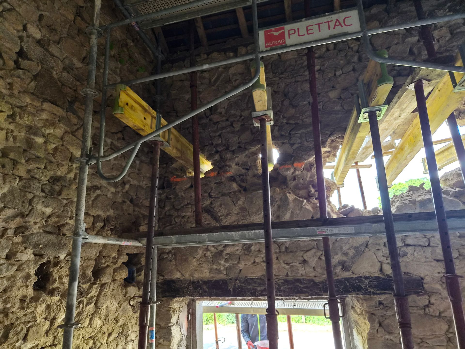 Structure en pierre en construction avec échafaudages métalliques