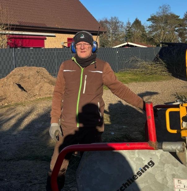 Ein Mann mit Kopfhörern steht neben einer Maschine, auf der „Chiesing“ steht