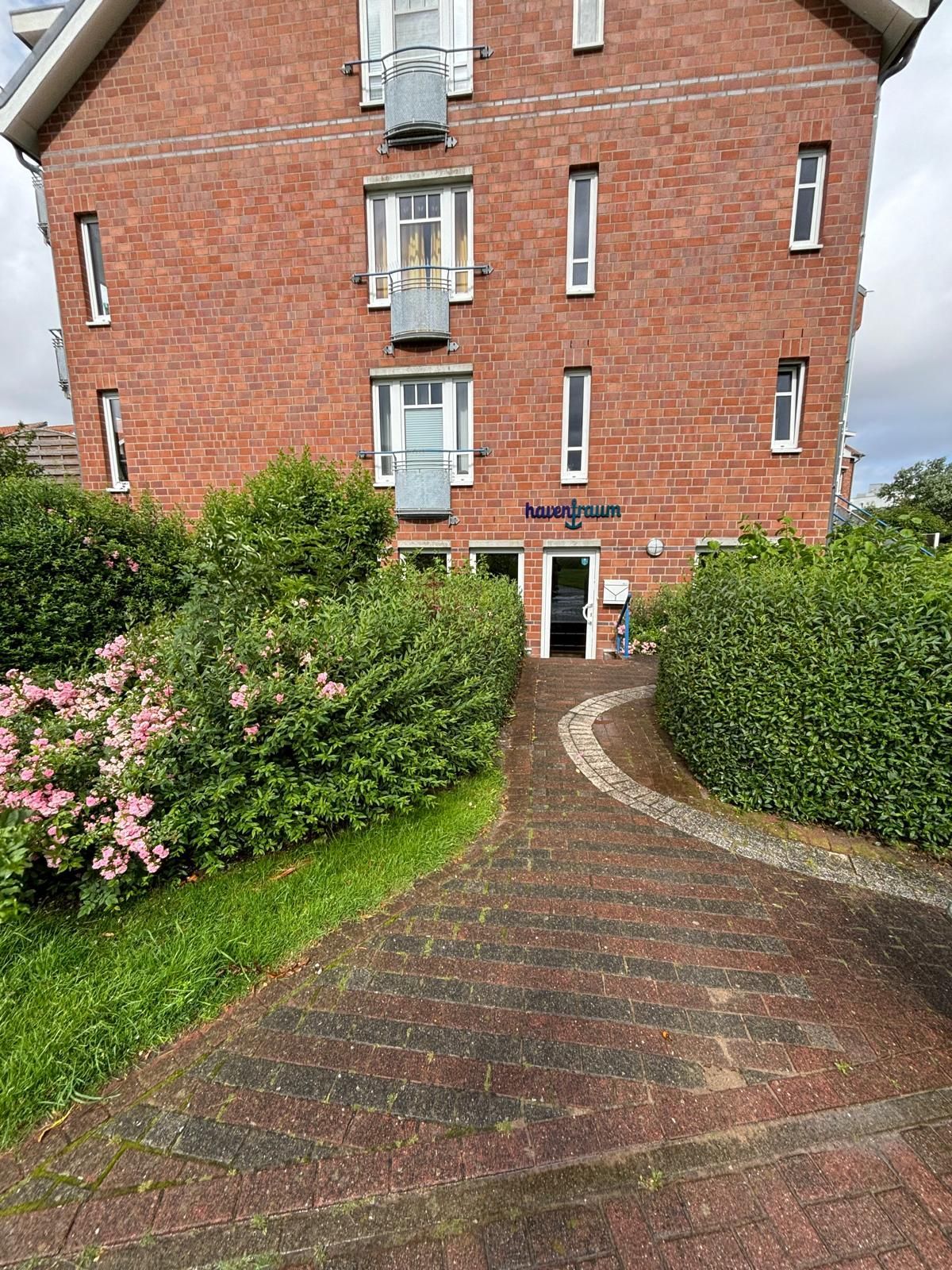 Ein Backsteingebäude, zu dem ein Backsteinweg führt.