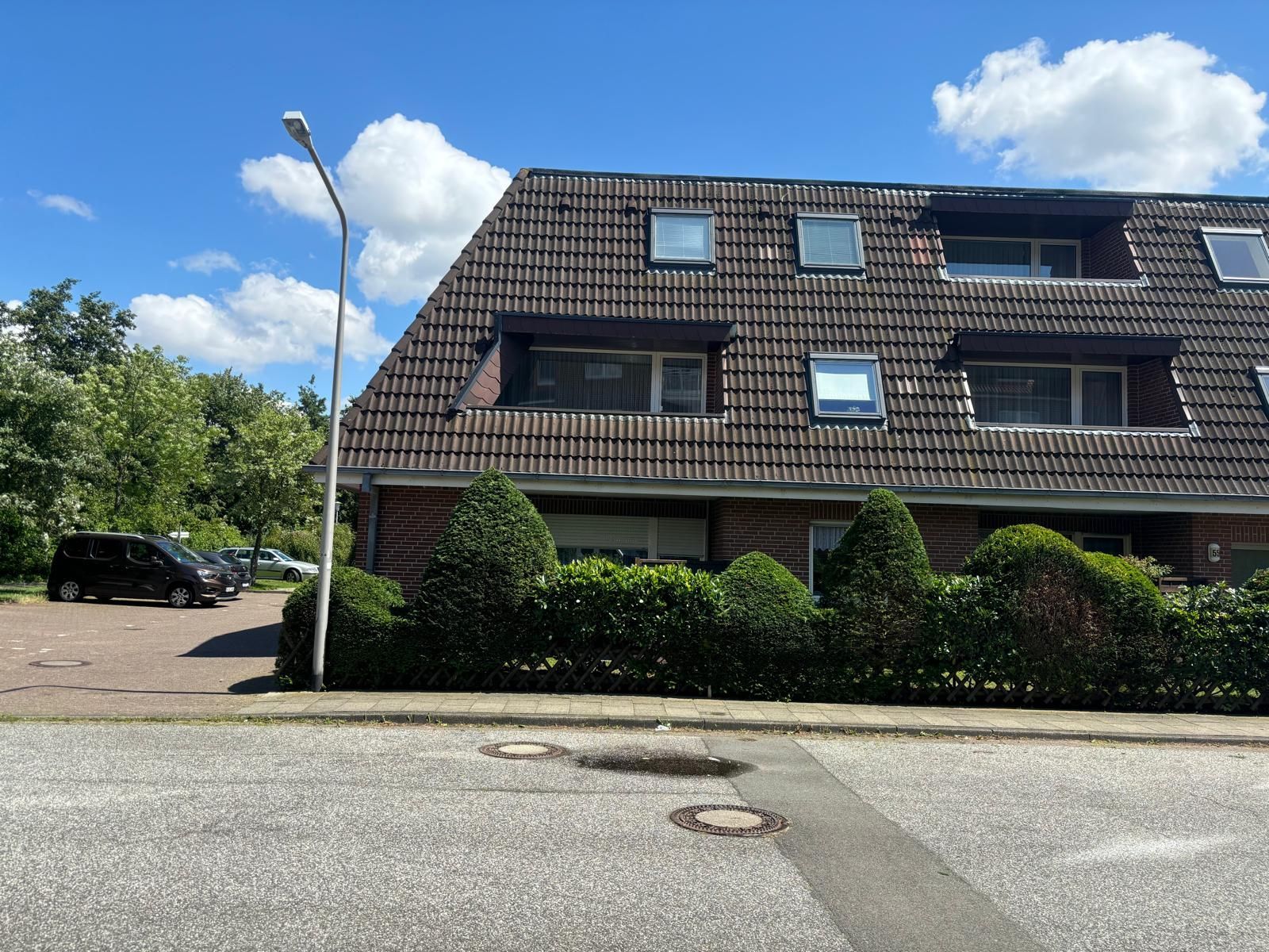 Ein großes Haus mit vielen Fenstern und einem davor geparkten Auto