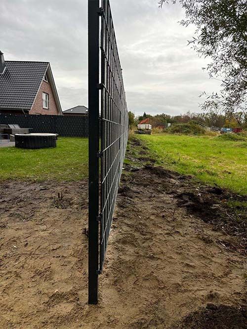 In einem Hof ​​neben einem Haus wird ein Zaun gebaut.