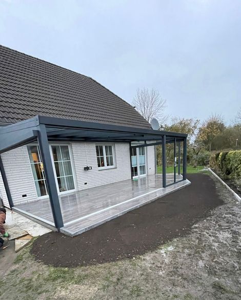 Ein weißes Haus mit einer großen Terrasse davor.