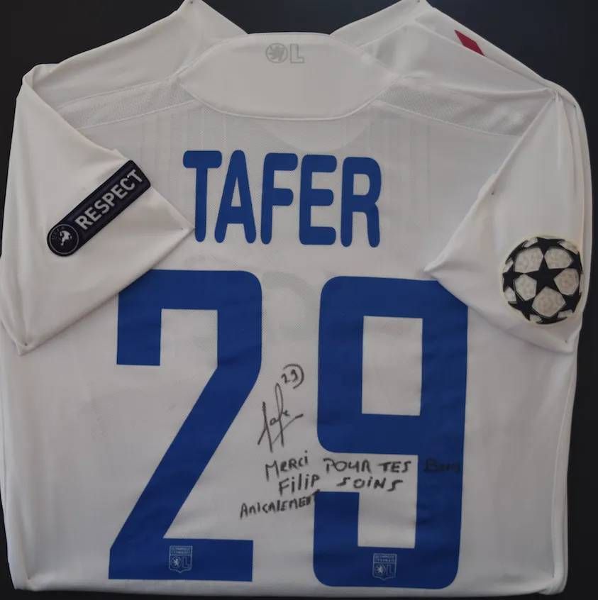 Maillot de football blanc floqué « TAFER » et « 29 », avec la dédicace « Merci Filip ». Les logos « Respect » et de la Ligue des champions sont également visibles.