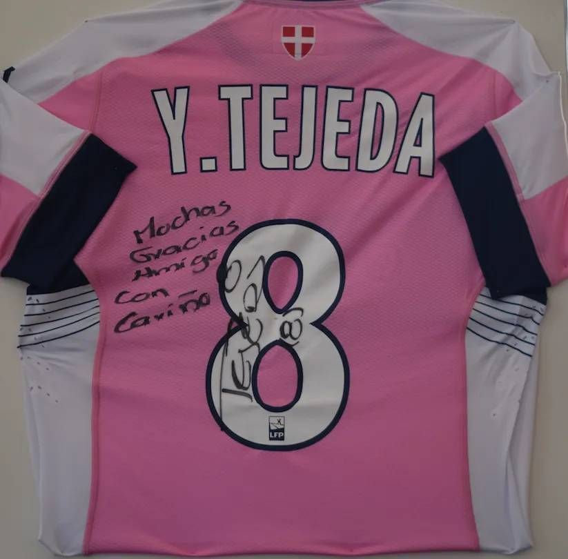 Maillot de football rose et blanc avec « Y. TEJEDA 8 », une signature et un message en espagnol.
