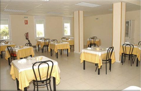 Un comedor lleno de mesas y sillas con fundas amarillas.