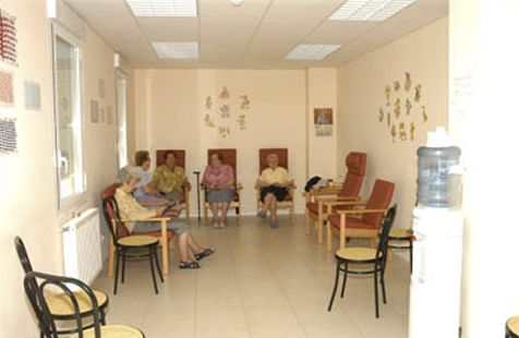 Un grupo de personas están sentadas en sillas en una sala de espera.