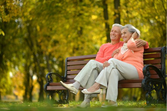 Una pareja de ancianos está sentada en un banco del parque.