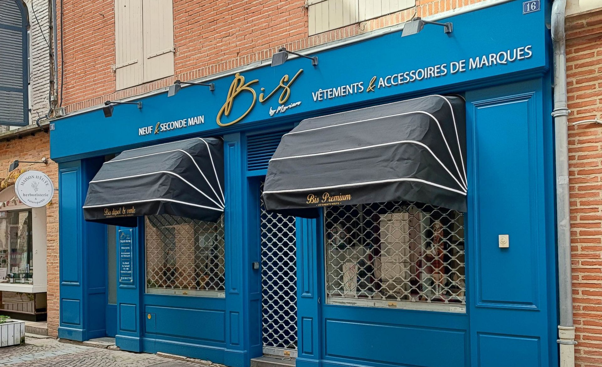 La façade d'un magasin de vêtements nommé Le Rendez-Vous des Copines, avec une façade gris foncé et une illustration au trait.