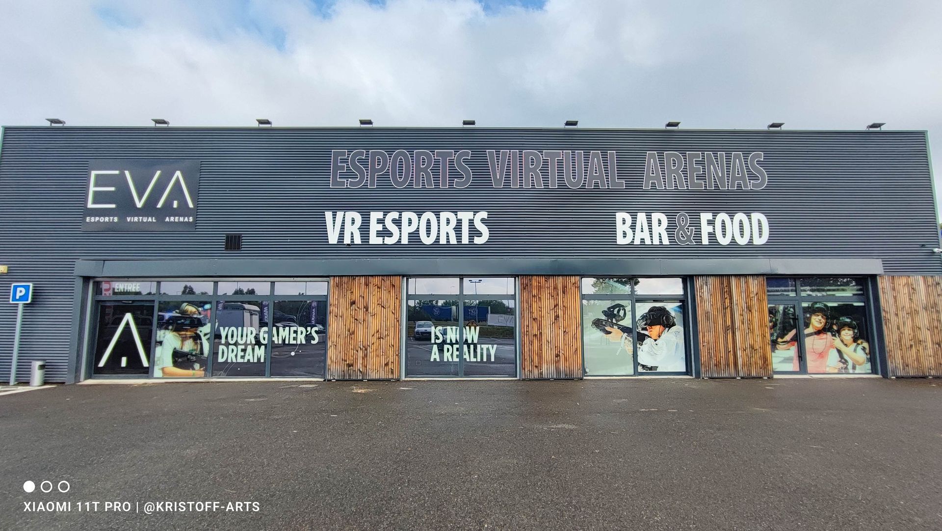 Vue de profil d'une voiture de course verte et noire avec des touches de blanc, garée dans un showroom.