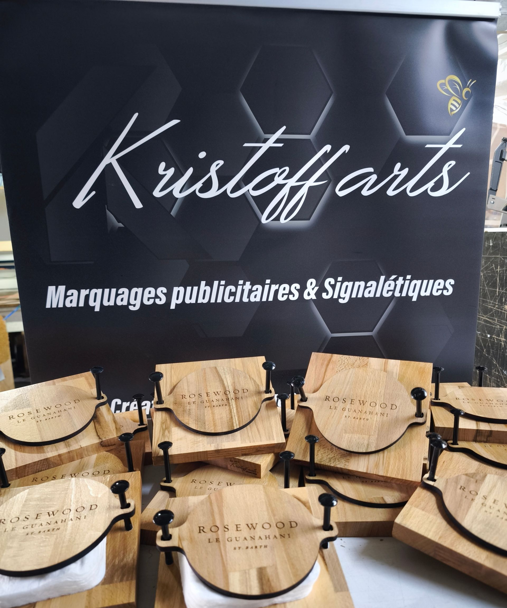 Une vitrine présentant des presses à fromage carrées et rondes en bois de marque Rosswood, devant une enseigne Kristoff Arts.