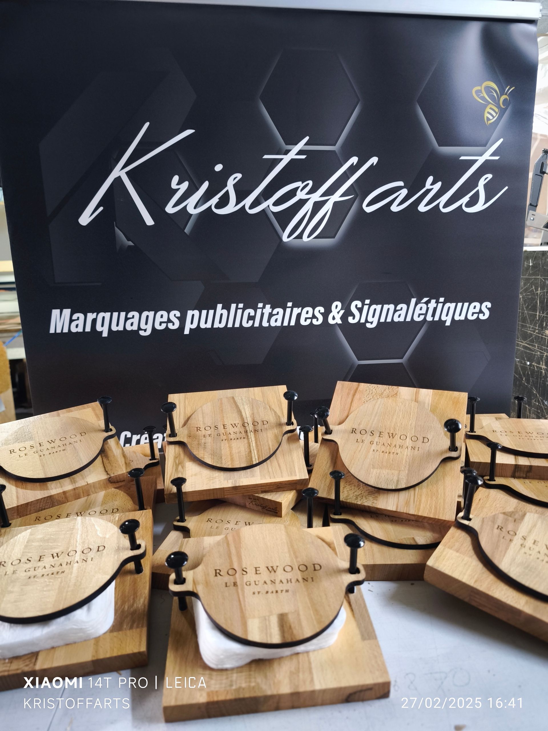 Une vitrine présentant des presses à fromage carrées et rondes en bois de marque Rosswood, devant une enseigne Kristoff Arts.