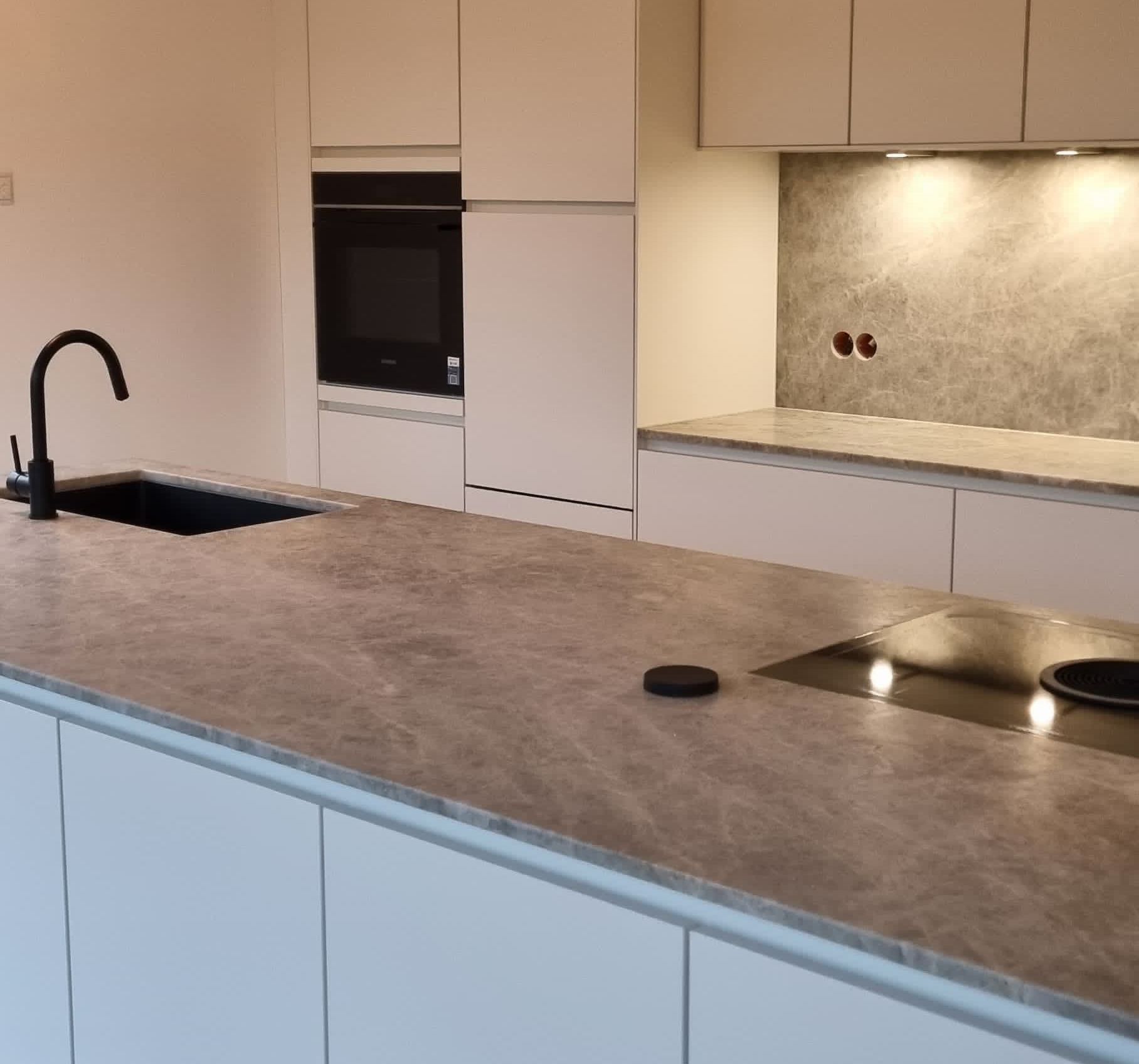 Eine Küche mit schwarzen Schränken und einer schwarzen Arbeitsplatte.