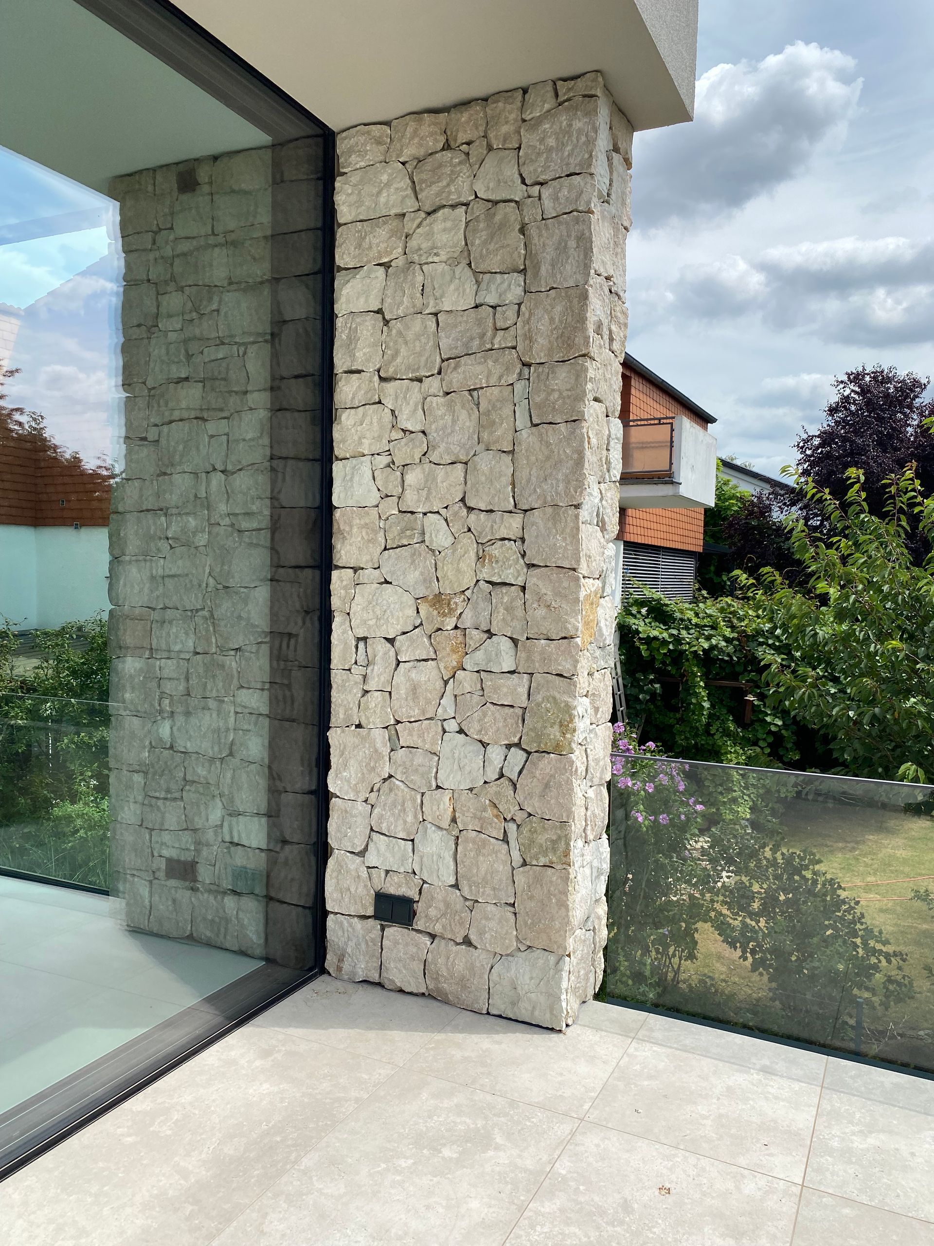 Ein weißes Haus mit vielen Fenstern und einem Balkon.