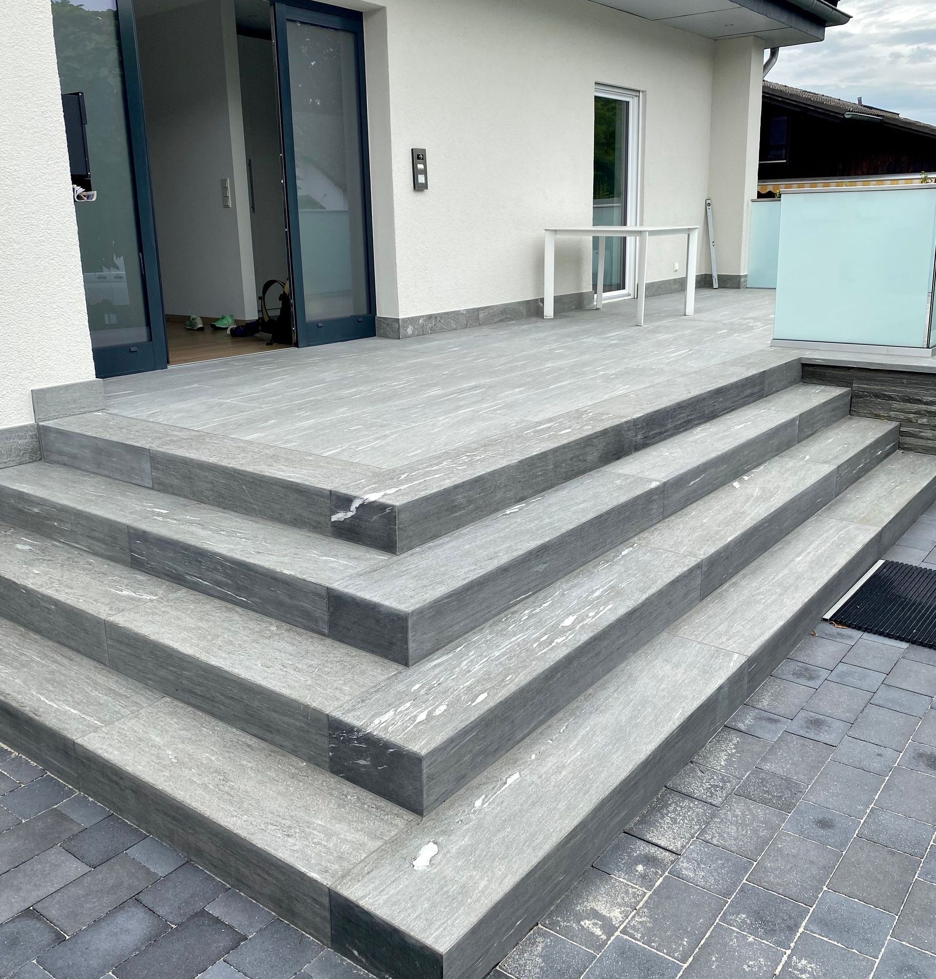 Ein Wohnzimmer mit Couch und Treppe, die in den zweiten Stock führt.