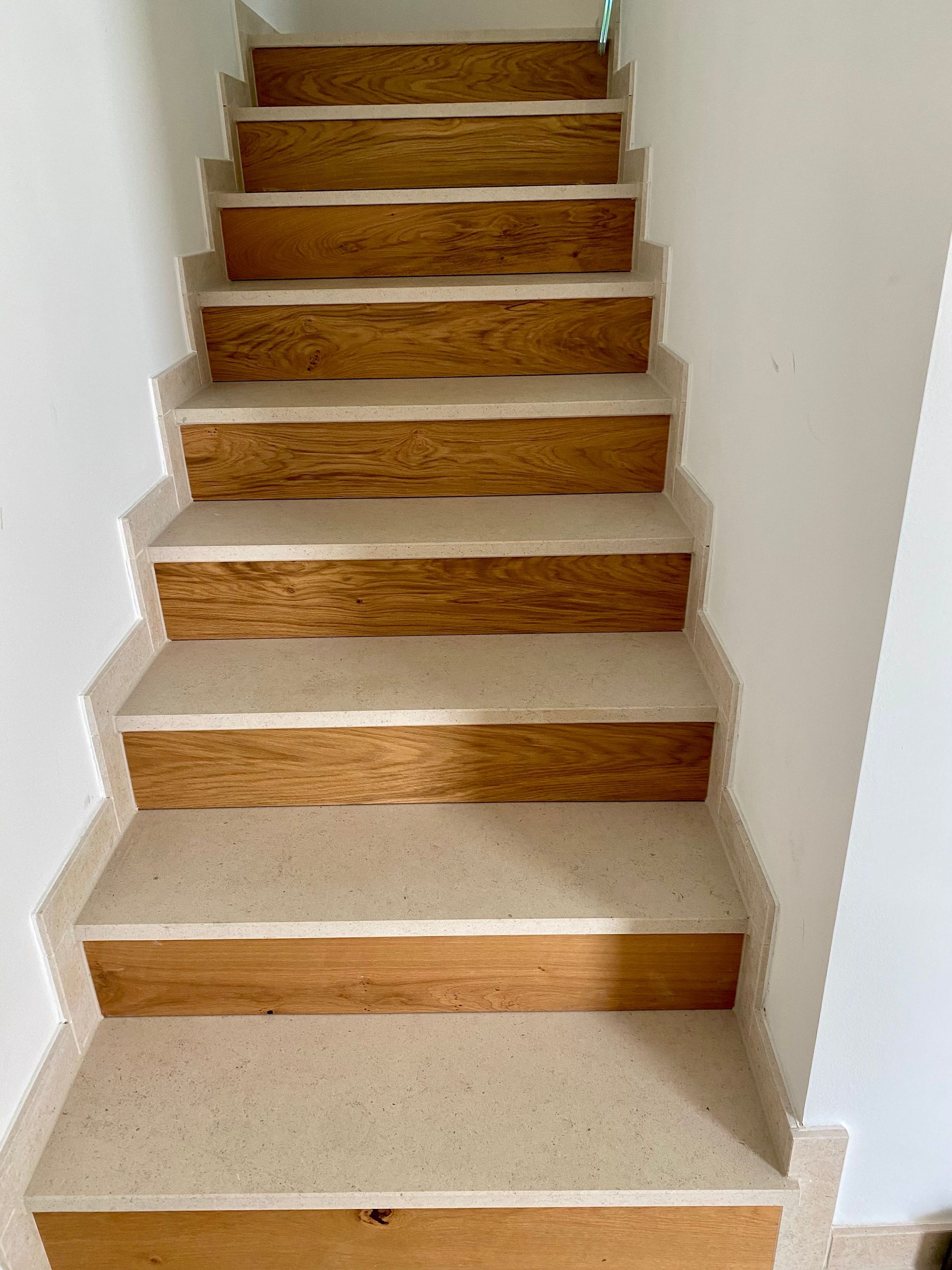 Ein Wohnzimmer mit Couch und Treppe, die in den zweiten Stock führt.