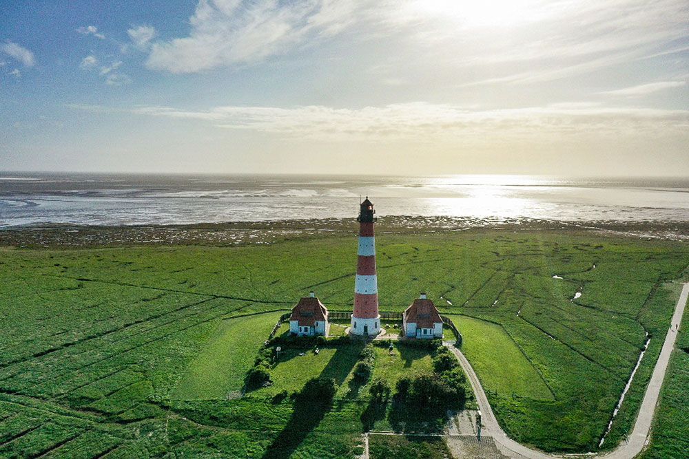 Eine Luftaufnahme eines Leuchtturms inmitten einer Wiese.