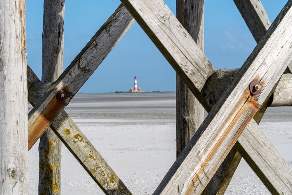 Ein Holzzaun mit einem Leuchtturm im Hintergrund