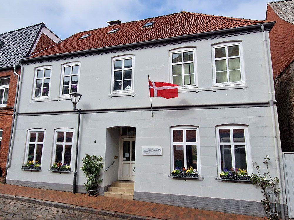 Ein weißes Gebäude mit einer roten Flagge davor