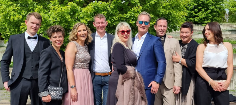 eine Gruppe von Menschen steht nebeneinander und posiert für ein Foto .