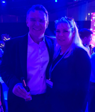 ein Mann und eine Frau posieren für ein Foto in einem dunklen Raum .