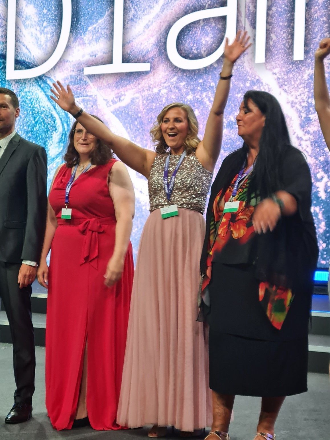 eine Gruppe von Frauen steht nebeneinander und hält ihre Hände in der Luft .