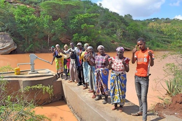 eine Gruppe von Menschen steht neben einem Brunnen .