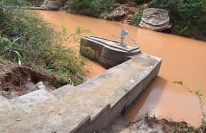 ein Mann pumpt Wasser aus einem Fluss .