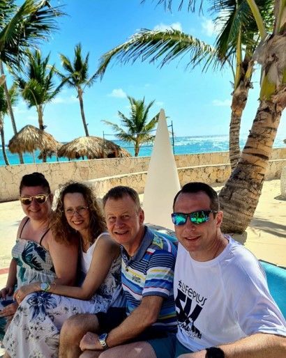 eine Gruppe von Menschen sitzt an einem Strand und posiert für ein Foto .