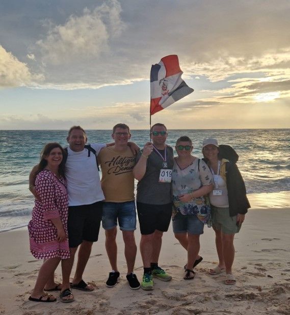 eine Gruppe von Menschen steht am Strand und hält eine Flagge