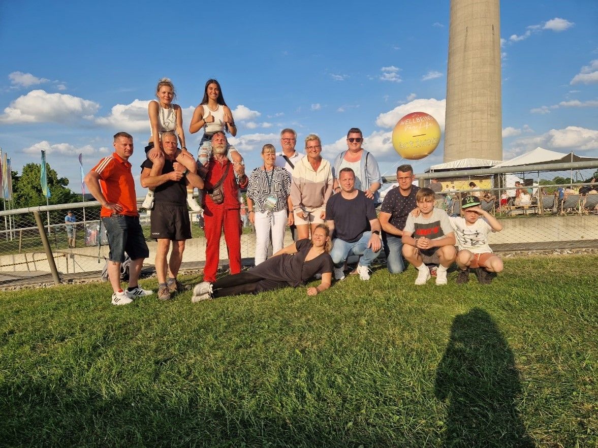 eine Gruppe von Menschen posiert für ein Foto auf einer Wiese .