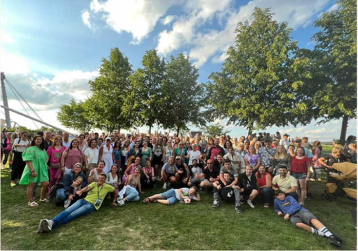 eine große Gruppe von Menschen posiert für ein Foto in einem Park .