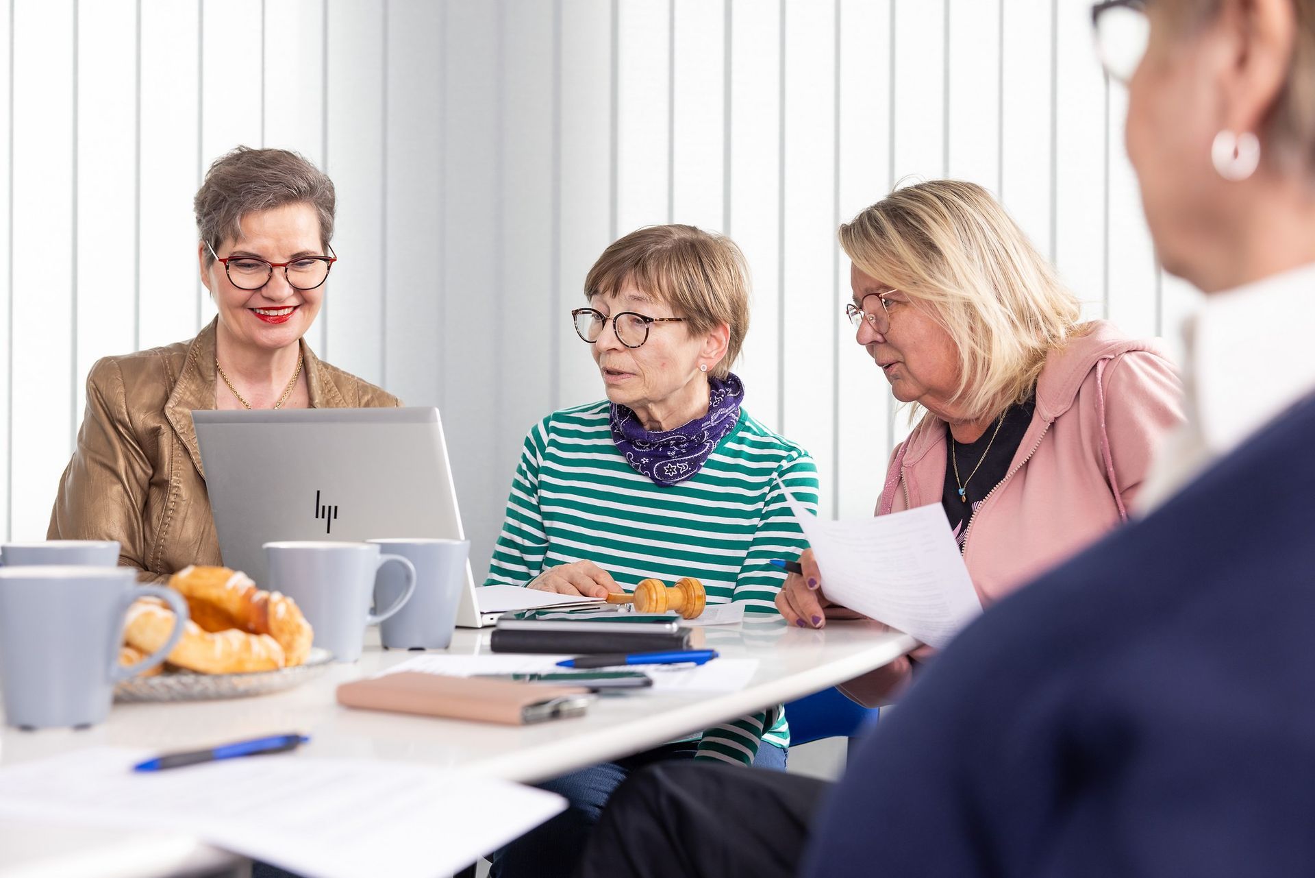 Taloyhtiön hallituksen jäseniä pöydän ääressä pohtimassa yhtiövastikkeen suuruutta.