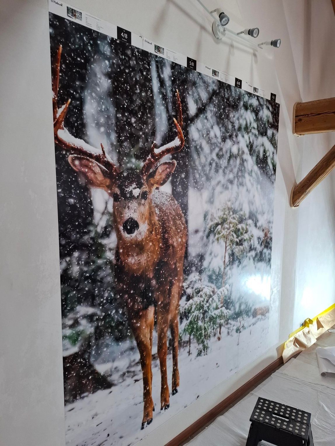 Scène de cerfs dans une forêt enneigée, imprimée sur un grand panneau de tissu suspendu.