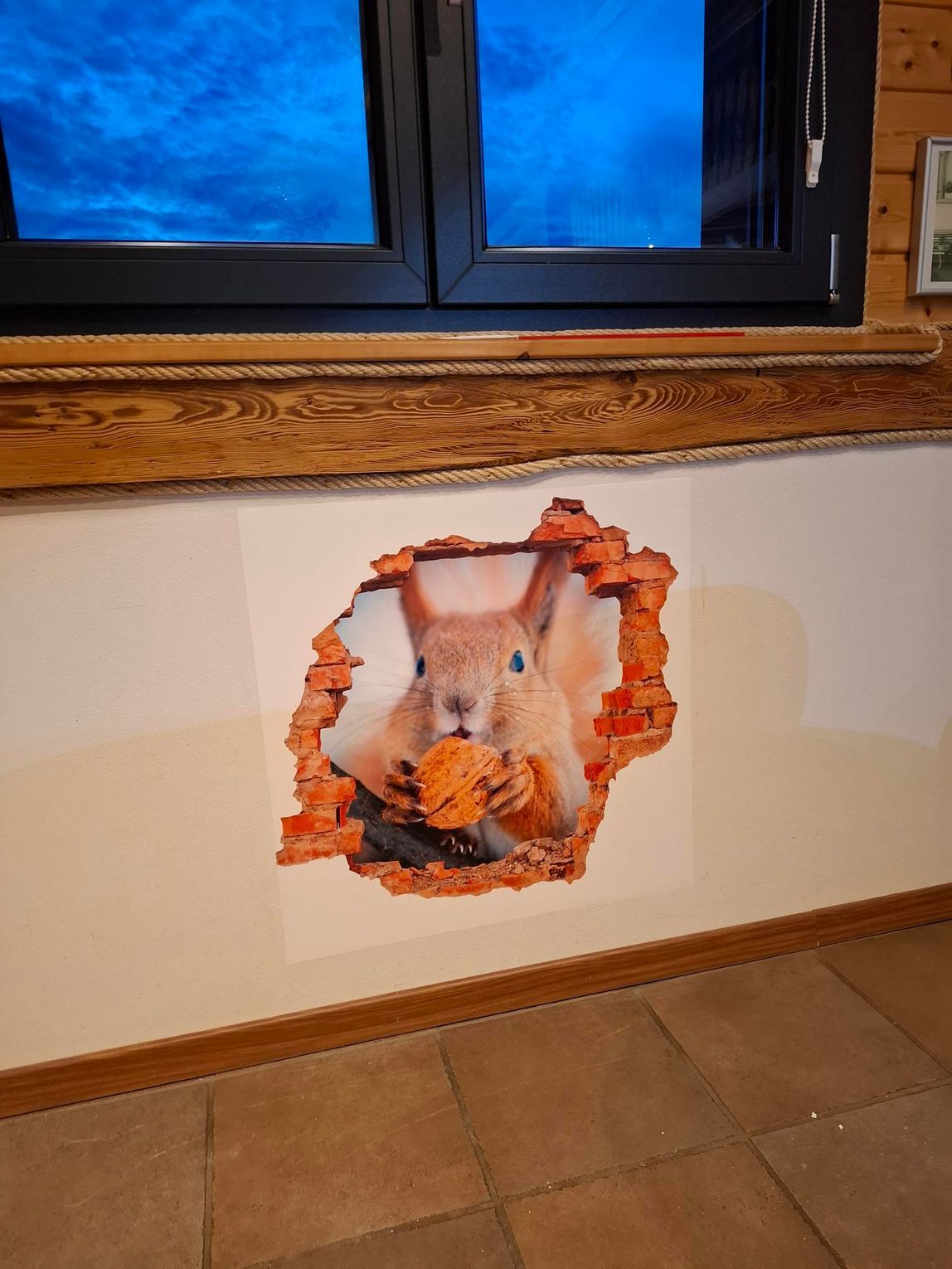 une main tenant un rouleau de peinture et en train de peindre un mur