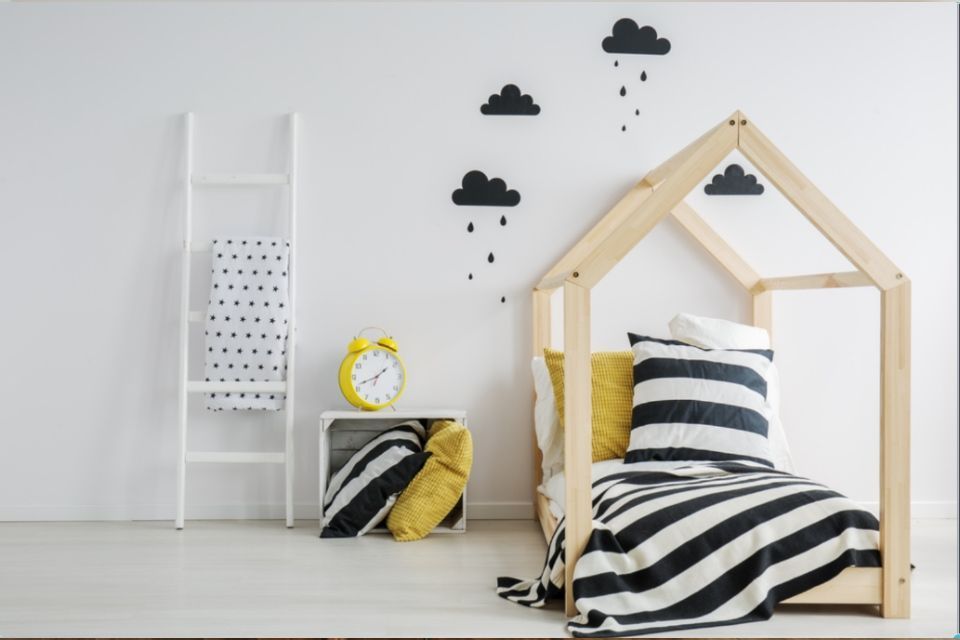 Lastenhuone: Talon muotoinen sänky, mustavalkoraidallinen peitto/tyyny, keltaiset tyynyt, valkoiset tikkaat, musta pilvikoristelu.
