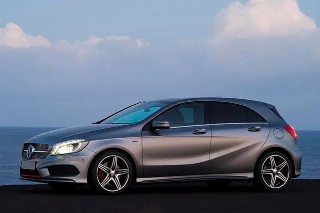 Un Mercedes Benz Clase A hatchback plateado está estacionado al lado del océano.