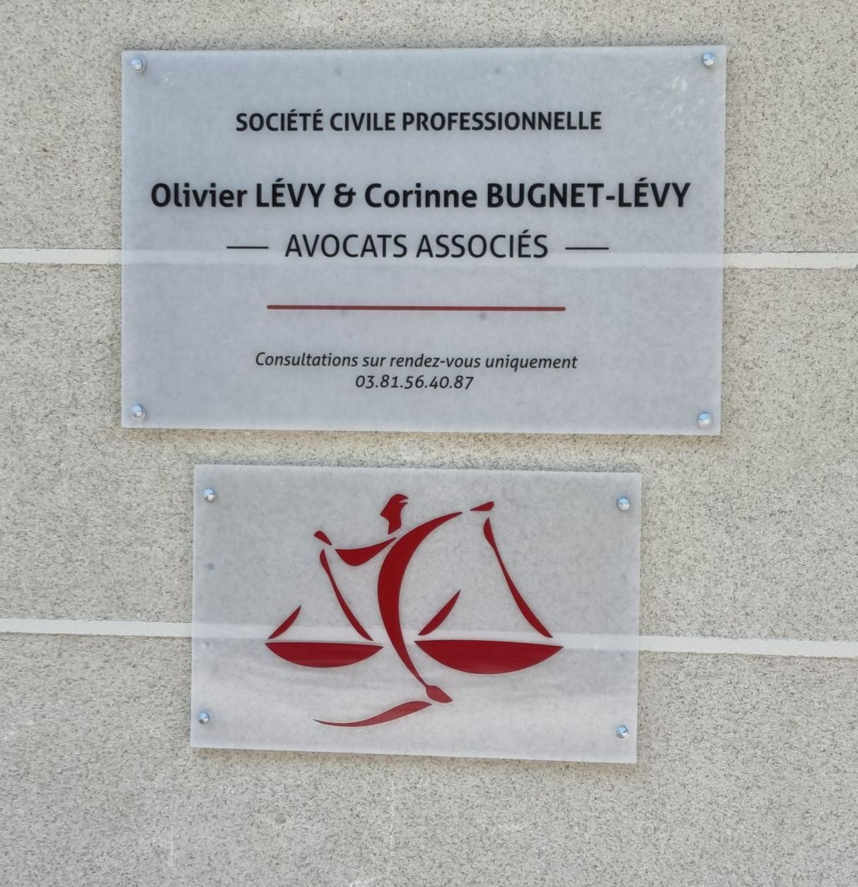 Plaque professionnelle sur laquelle est inscrit le nom du cabinet d'avocats