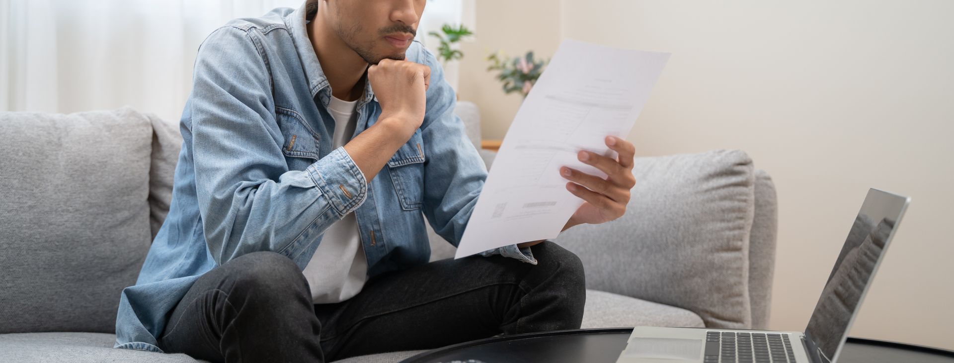 Homme posé dans un canapé lisant un document