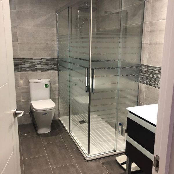 Un baño con inodoro y ducha a ras de suelo.