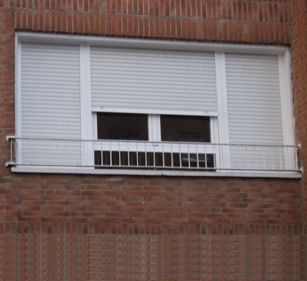 Un edificio de ladrillo con una ventana con contraventanas.