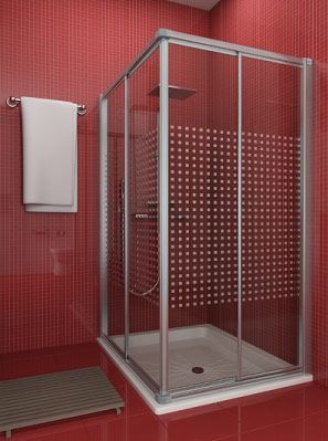 Un baño con azulejos rojos y una cabina de ducha con puertas corredizas de vidrio.