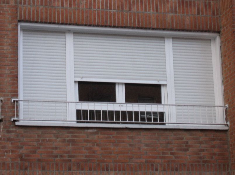 Un edificio de ladrillo con una ventana con contraventanas.