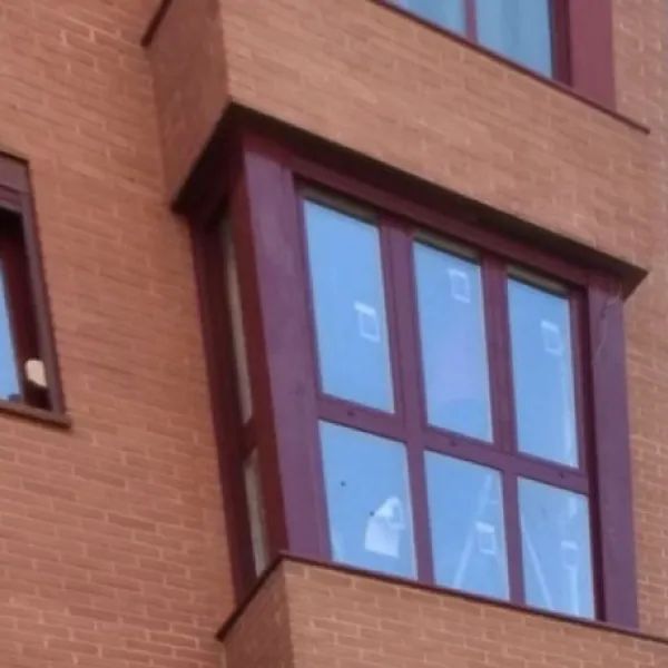 Un edificio de ladrillo con una gran ventana en el lateral.