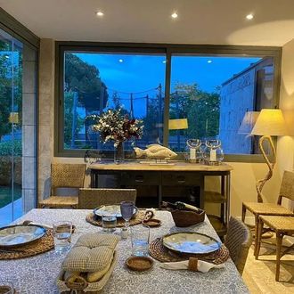 Un comedor con mesa y sillas y un gran ventanal.