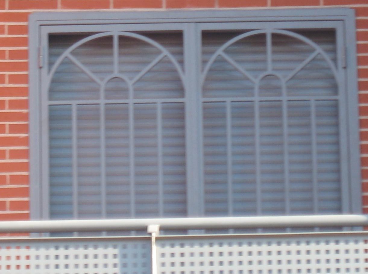 Un edificio de ladrillo con una ventana con marco de metal.