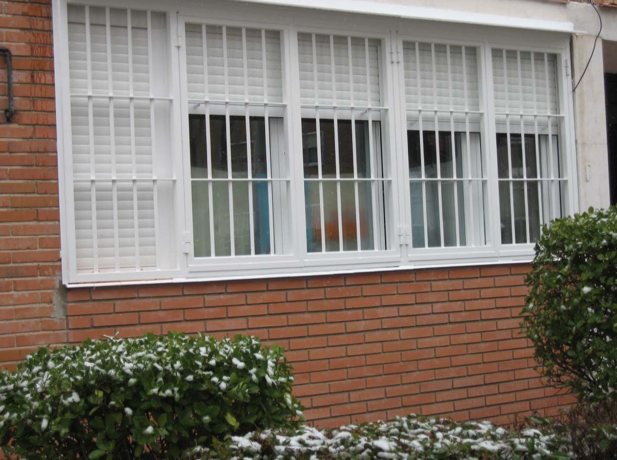 Un edificio de ladrillo con una ventana blanca con rejas.