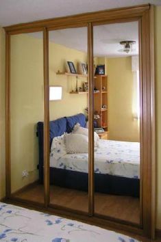 Un dormitorio con una cama y un armario con espejo.